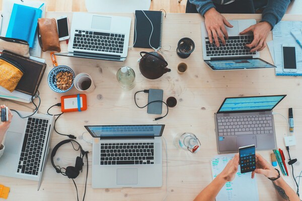 Une table avec plein d'ordinateurs